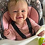 Maci joined the competition — help win amazing prizes! baby, high_chair, smiling, child, snack, pink_clothing, toy, seatbelt, indoor, face, happy, cheeks, hand, food, feeding, pattern, cushion, seat, person, portrait