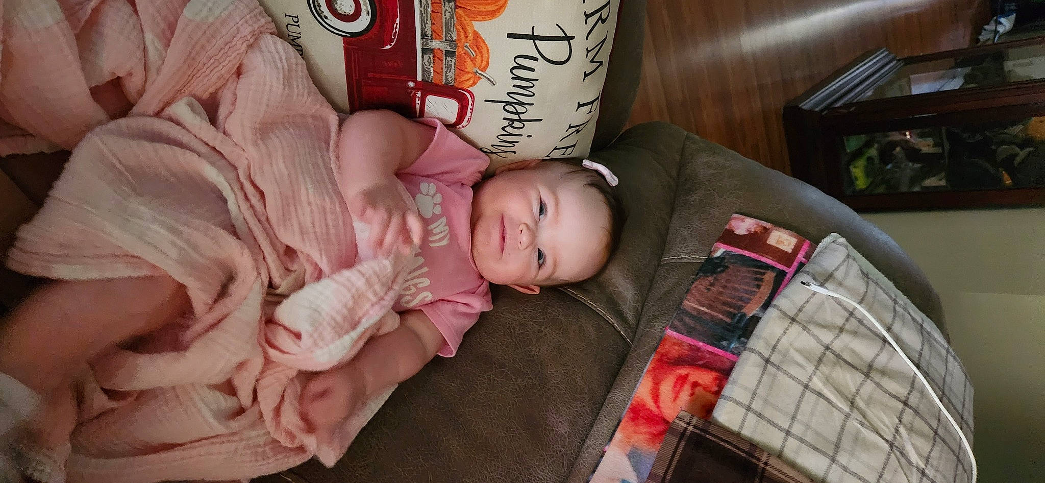 Oaklyn is registered to the contest to win money with this photo: baby, baby_products, baby_toddler_clothing, carmine, cheek, child, comfort, font, pattern, person, plaid, room, sitting, skin, tartan, textile, toddler, wood