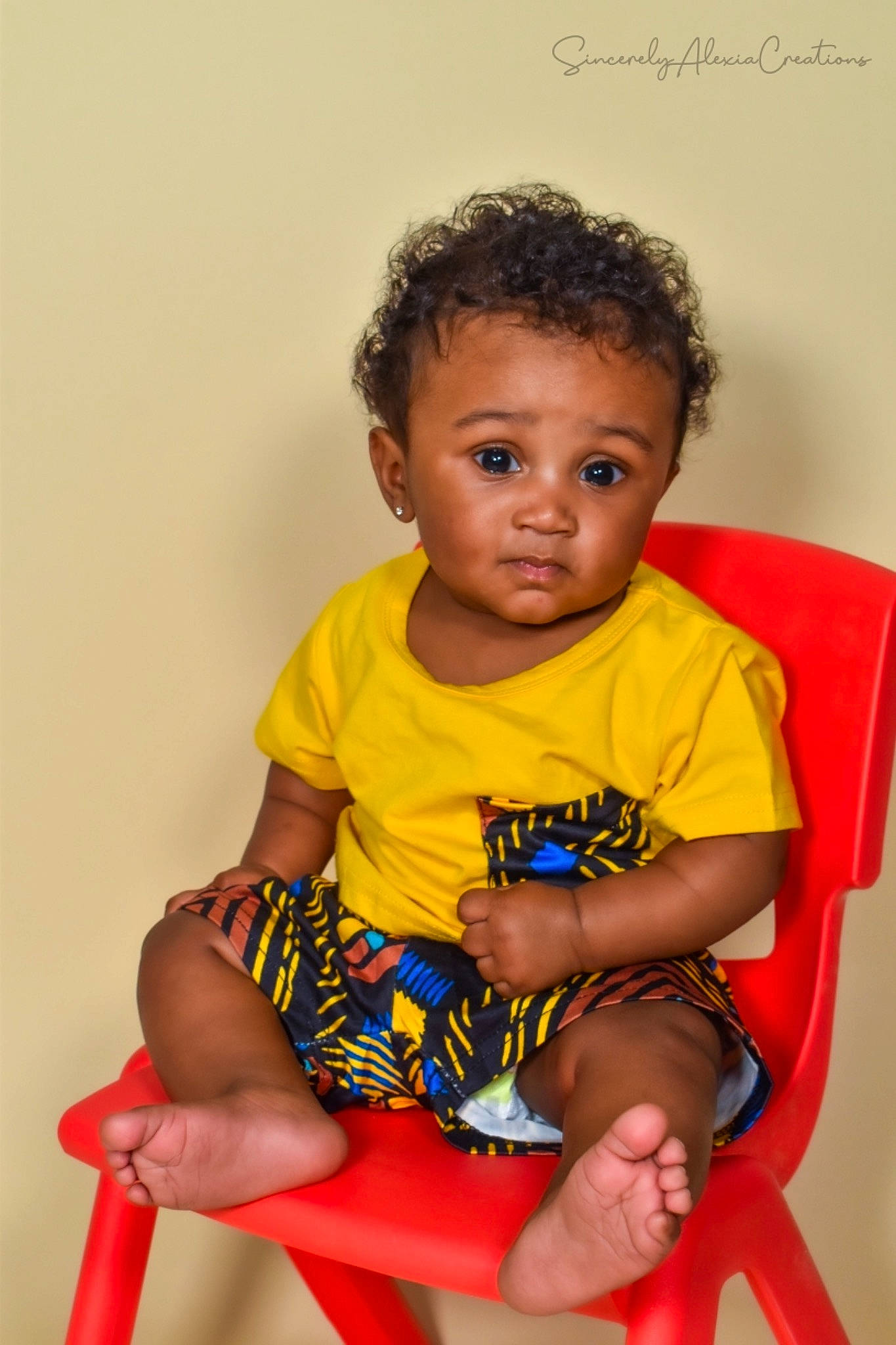 Ahmir is registered to the contest to win money with this photo: baby, baby_toddler_clothing, barefoot, cheek, child, face, foot, fun, happy, human_body, human_leg, joint, knee, person, shorts, shoulder, sitting, sleeve, t_shirt, thigh