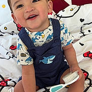 Daniel joined the competition — help win amazing prizes! toddler, child, smiling, sitting, bed, hello_kitty, bedding, brush, clothing, shark, footwear, sneakers, indoor, cute, happy, person, face, toy, furniture, playful
