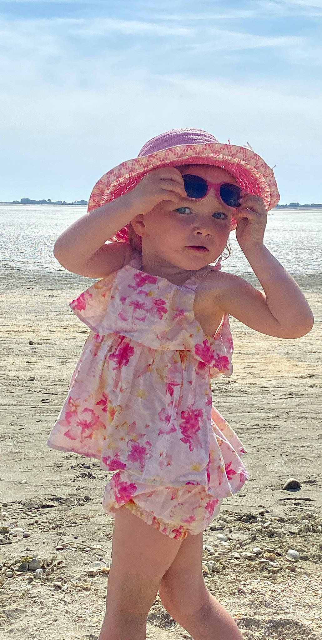 Lily participe au concours pour gagner de l'argent avec cette photo : baby_toddler_clothing, beach, dress, eyewear, face, goggles, hand, happy, hat, headgear, headwear, lip, people_in_nature, people_on_beach, person, pink, skin, sky, sleeve, sun_hat