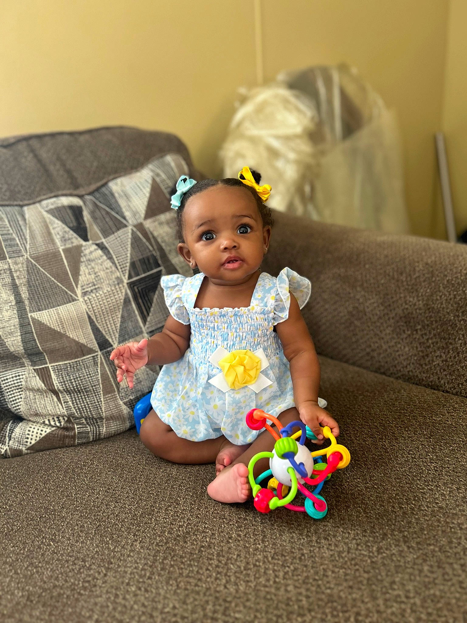 Alaya is registered to the contest to win money with this photo: baby, baby_playing_with_toys, baby_products, baby_toddler_clothing, child, comfort, couch, dress, flooring, fun, happy, head, leisure, pattern, person, plaid, play, room, sitting, t_shirt