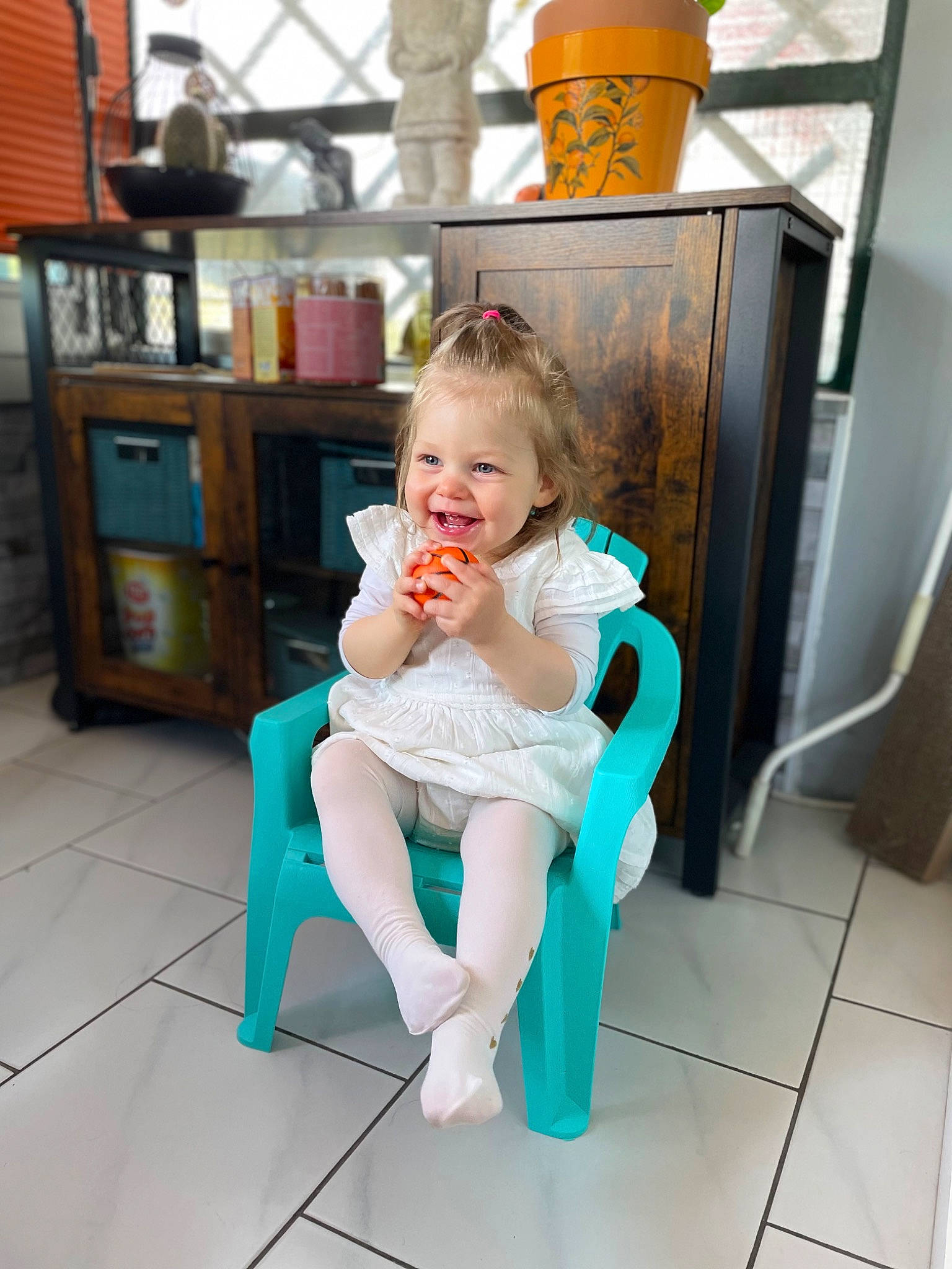 Maëla a rejoint le concours — aidez-le/la à gagner de superbes lots ! baby, barefoot, brown_hair, chair, comfort, floor, flooring, foot, happy, human_leg, joint, knee, leg, leisure, person, shelf, shoe, sportswear, thigh, toddler