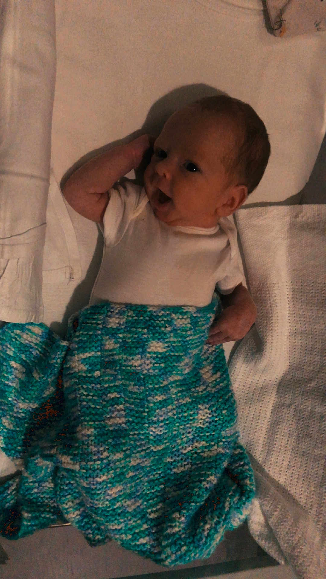 Issac joined the competition — help win amazing prizes! baby, infant, blanket, knitted, white, blue, clothing, lying_down, face, head, arm, hand, expression, curious, playful, indoor, soft_texture, fabric, newborn, cute