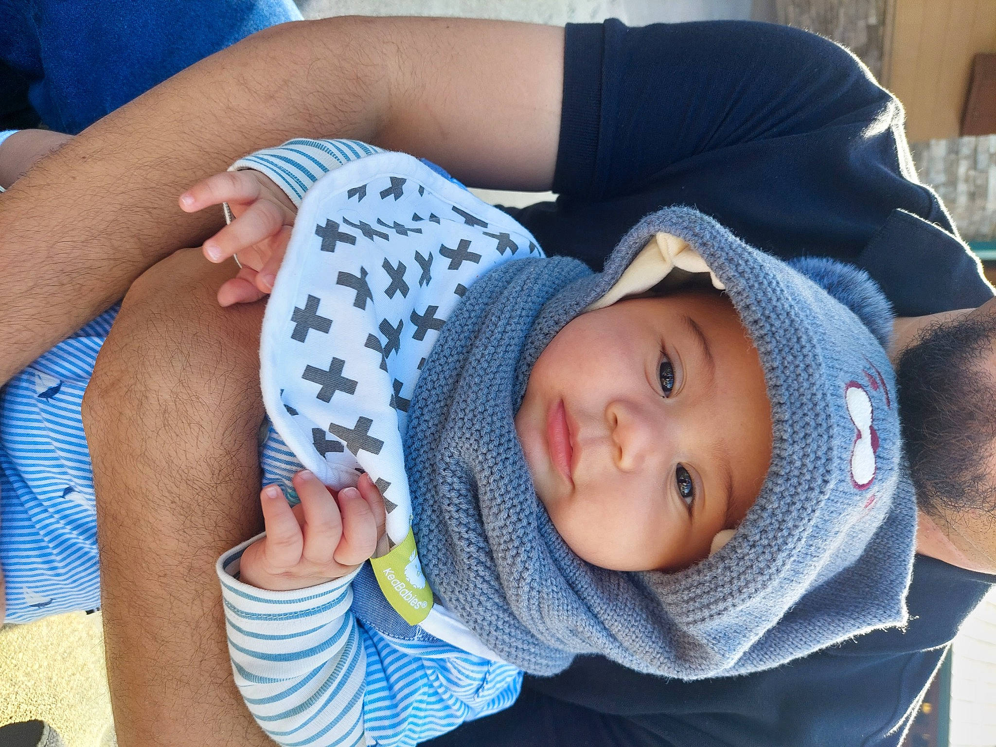 Evan is registered to the contest to win money with this photo: baby, baby_toddler_clothing, blue, cap, cheek, child, comfort, eye, facial_expression, grass, hand, hat, headgear, headwear, mouth, person, skin, sun_hat, textile, thigh