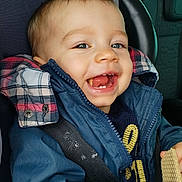 Elyass a rejoint le concours — aidez-le/la à gagner de superbes lots ! toddler, child, smiling, happy, car_seat, seatbelt, blue_jacket, snack, wafer, indoor, portrait, cute, baby, clothing, hands, face, head, car_interior, window, seat