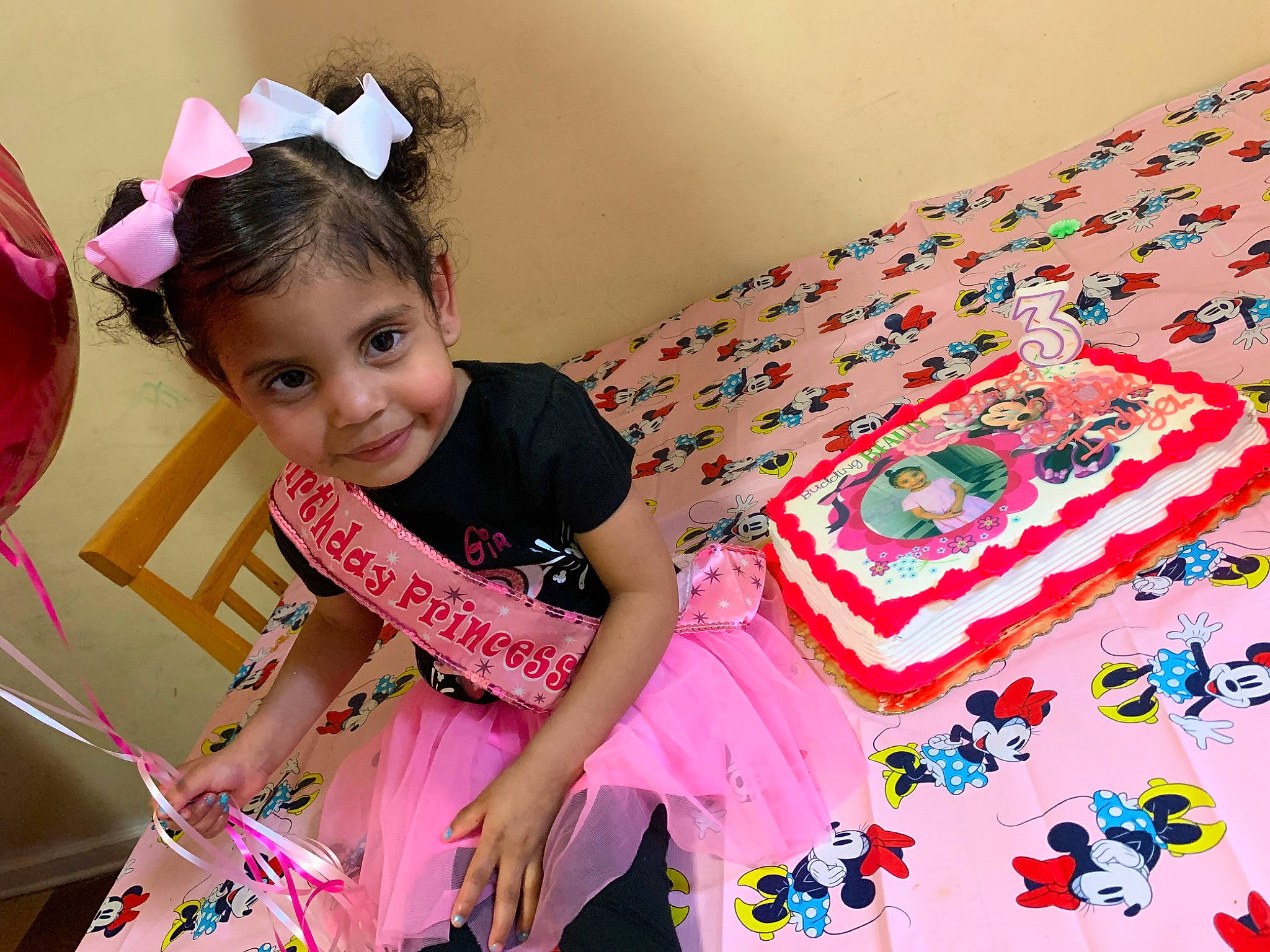 Indya is registered to the contest to win money with this photo: baby_toddler_clothing, birthday_party, child, event, eyelash, fun, happy, joy, leisure, magenta, party, pattern, person, pink, play, sitting, sleeve, smile, sweetness, t_shirt