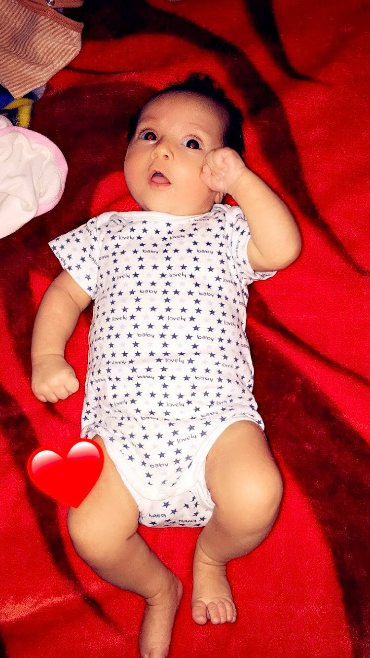 Rahela participe au concours pour gagner de l'argent avec cette photo : arm, baby, baby_toddler_clothing, cheek, comfort, facial_expression, finger, hand, human_body, joint, leg, lip, mouth, neck, organ, person, pink, skin, sleeve, thigh