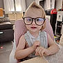 toddler, child, glasses, high_chair, indoor, living_room, table, curious, smile, blond_hair, baby, person, furniture, window, curtains, television, cabinet, toy, clothing, face