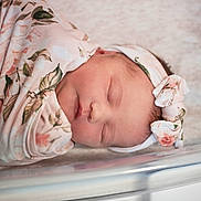 Sawyer joined the competition — help win amazing prizes! baby, bassinet, close_up, cute, face, floral_pattern, headband, hospital, indoors, infant, newborn, peaceful, person, portrait, resting, sleeping, soft_light, swaddle, wrapped, young_child
