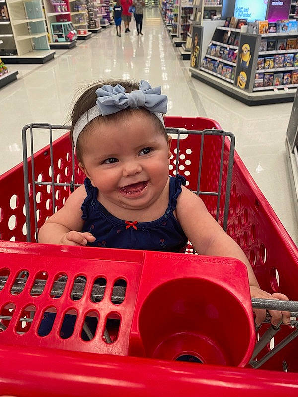 Delilah is registered to the contest to win money with this photo: automotive_design, baby, baby_toddler_clothing, child, convenience_store, customer, fun, happy, joy, leisure, magenta, motor_vehicle, person, play, recreation, retail, shelf, shopping_cart, sitting, smile