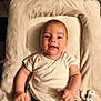 baby, infant, smiling, cushion, soft, changing_pad, white_clothing, indoor, happy, child, person, skin, face, cute, young, small, pale, lying_down, comfort, peaceful