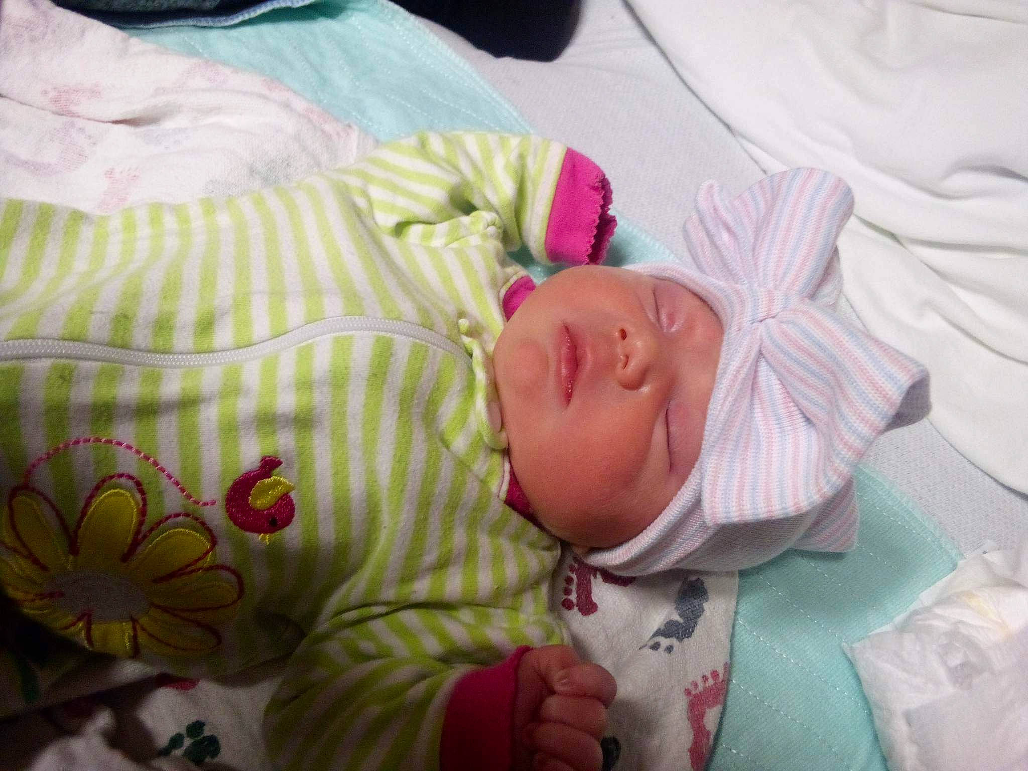 Justice is registered to the contest to win money with this photo: baby, baby_products, baby_safety, baby_sleeping, baby_toddler_clothing, bed, bedding, bedtime, cheek, child, comfort, hat, headwear, linens, mouth, person, pink, room, skin, sleeve