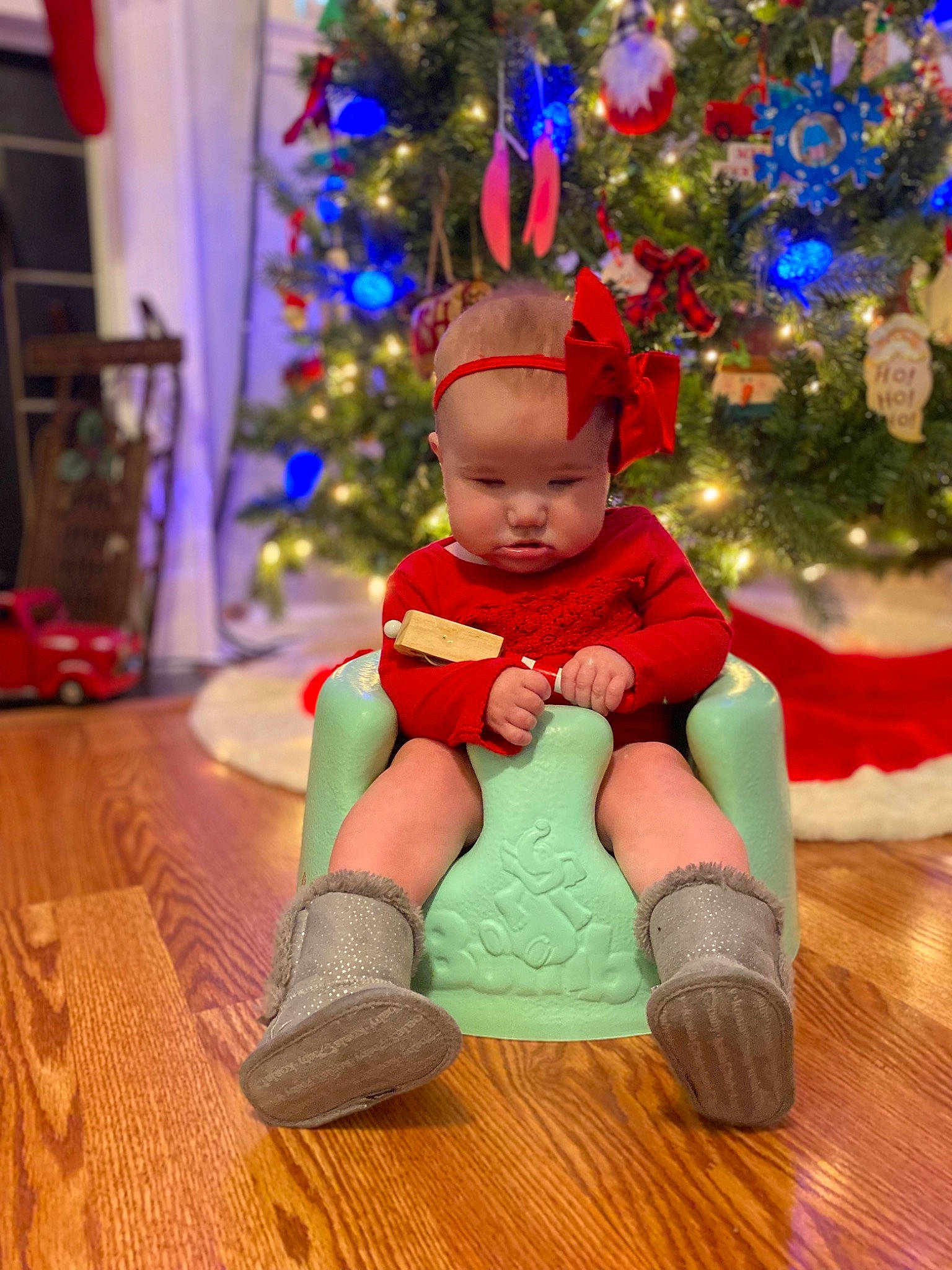 Macie is registered to the contest to win money with this photo: baby, baby_toddler_clothing, child, christmas, christmas_decoration, christmas_ornament, christmas_tree, event, flooring, fun, happy, holiday, holiday_ornament, ornament, person, shoe, sitting, sock, toddler, tree