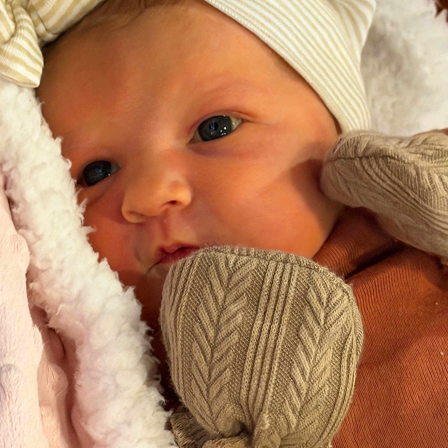 Lainey is registered to the contest to win money with this photo: baby, blanket, child, close_up, cozy, cute, face, hat, headwear, indoors, infant, mittens, newborn, person, portrait, resting, skin, sleepwear, soft_texture, warm_clothing