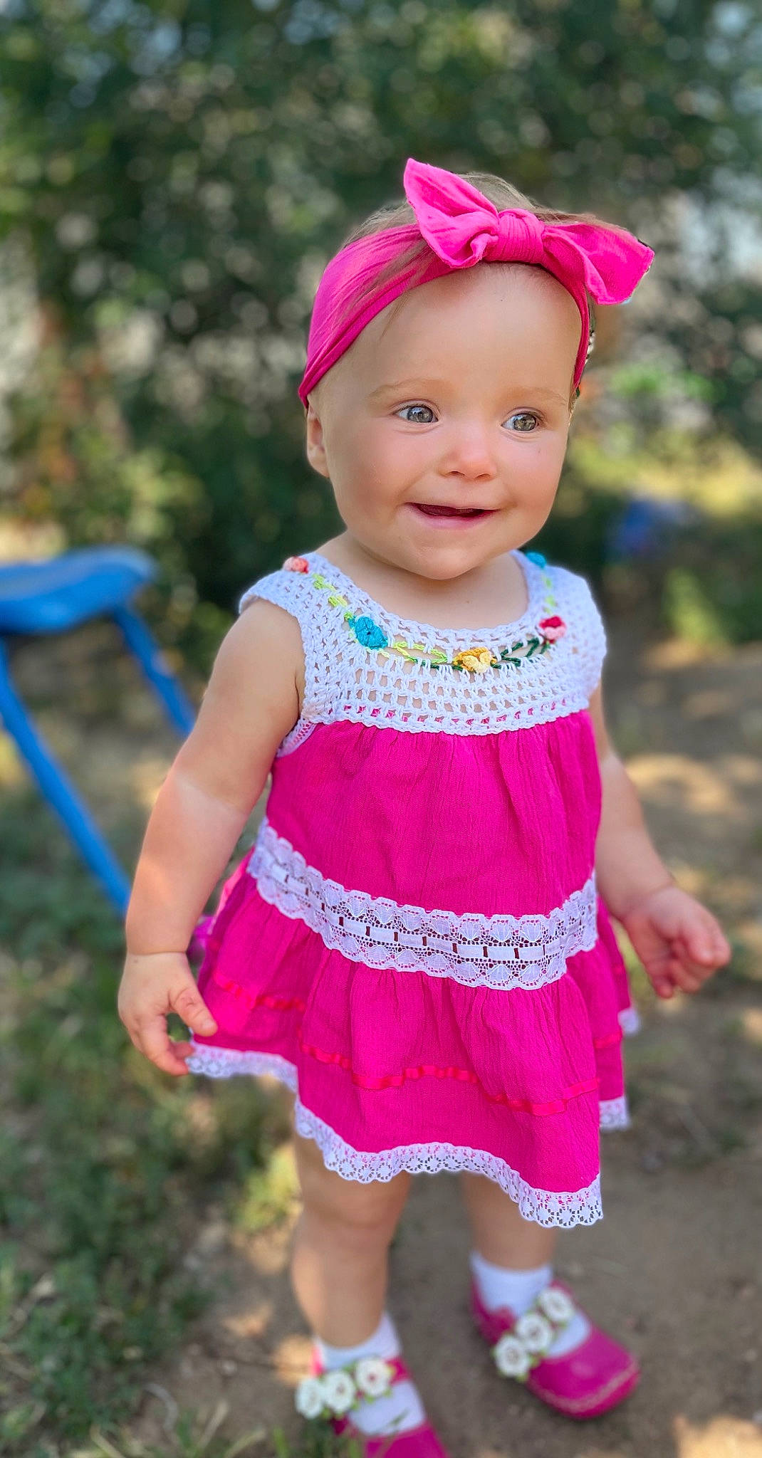 Fiona is registered to the contest to win money with this photo: baby_toddler_clothing, day_dress, dress, eye, face, grass, happy, headwear, joy, leaf, lip, magenta, one_piece_garment, person, pink, plant, purple, red, skin, sleeve