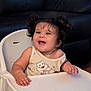 baby, child, couch, cute, face, furniture, hair, hands, happy, high_chair, indoor, infant, laughing, person, pigtails, portrait, smiling, tank_top, water_bottle, wooden_floor