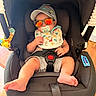 Dalton joined the competition — help win amazing prizes! baby, infant, child, car_seat, sunglasses, pacifier, baseball_cap, bib, dinosaur_pattern, harness, sitting, portrait, indoor, wood_floor, plush_toy, colorful, casual_clothing,  안전, smiling, photography