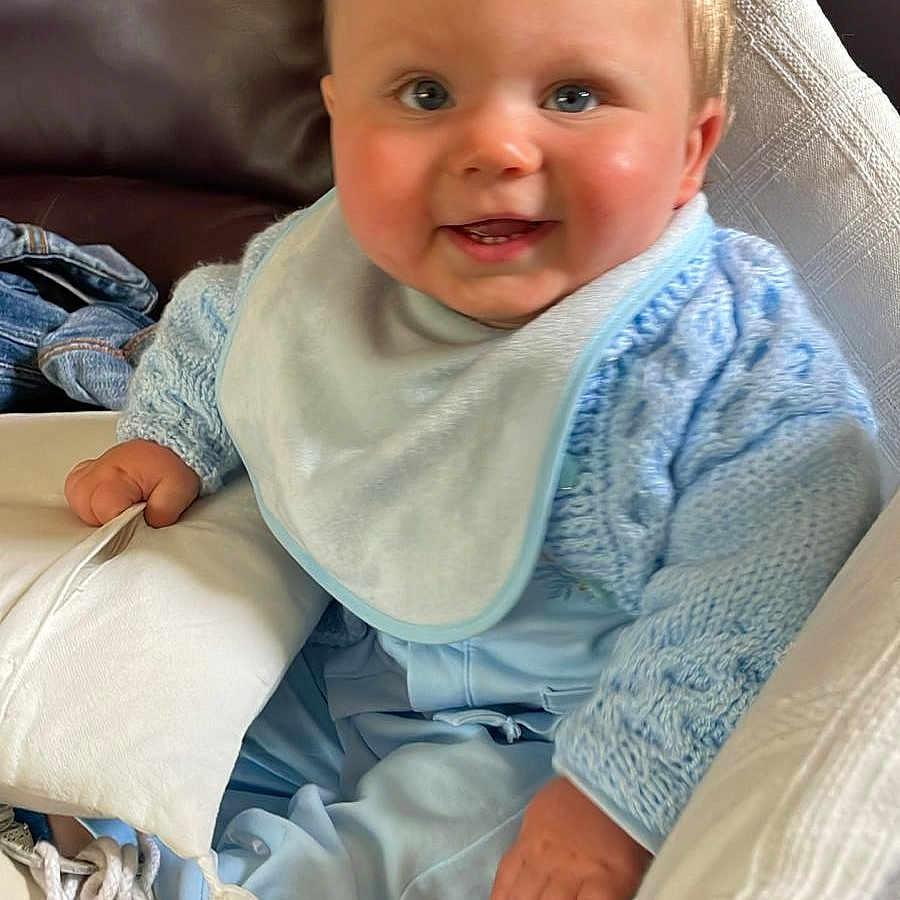 James Junior is registered to the contest to win money with this photo: baby, babylaughing, blonde, clothing, couch, cushion, face, footwear, furniture, hair, happy, head, homedecor, pants, person, photography, pillow, portrait, sitting, smile