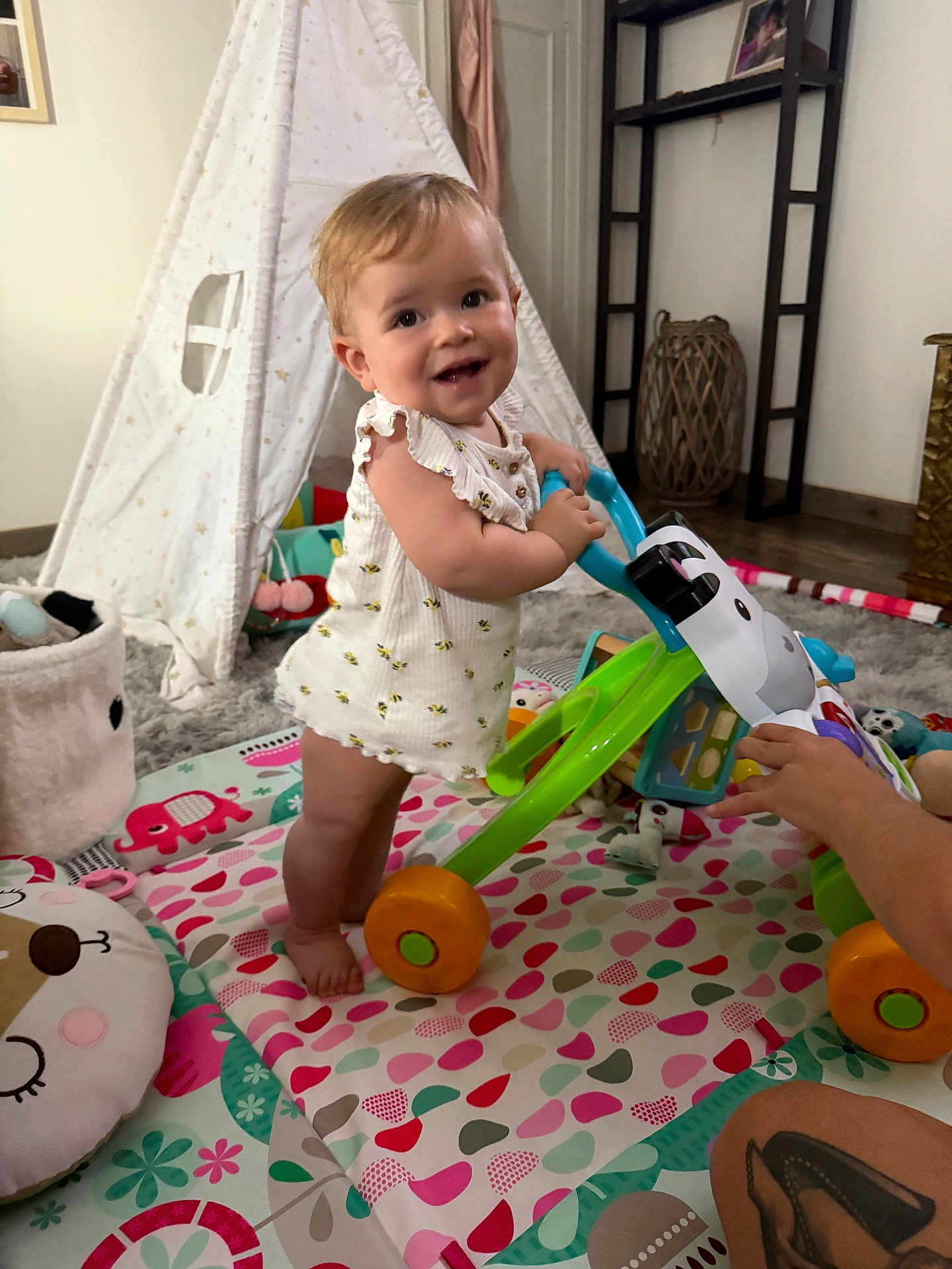 Maëlys participe au concours pour gagner de l'argent avec cette photo : toddler, baby_walker, indoor, play_mat, teepee, toy, child, smiling, happy, floor, colorful, footwear_free, tattoo, adult_hand, cushion, carpet, furniture, window, person, room