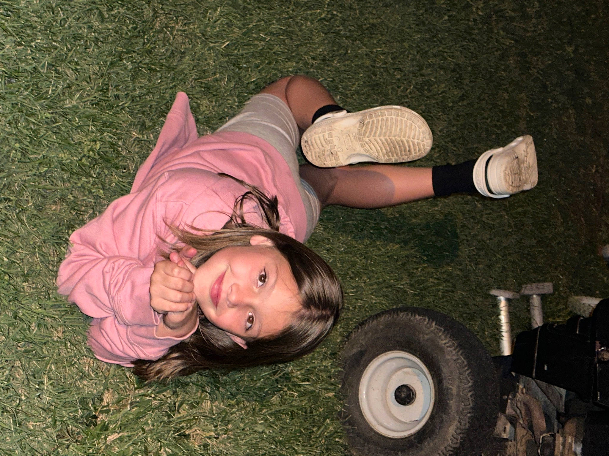 Miley is registered to the contest to win money with this photo: automotive_tire, automotive_wheel_system, eyewear, flash_photography, fun, grass, grassland, happy, human_leg, joy, landscape, leisure, people_in_nature, person, plant, sitting, soil, thigh, tints_and_shades, tire