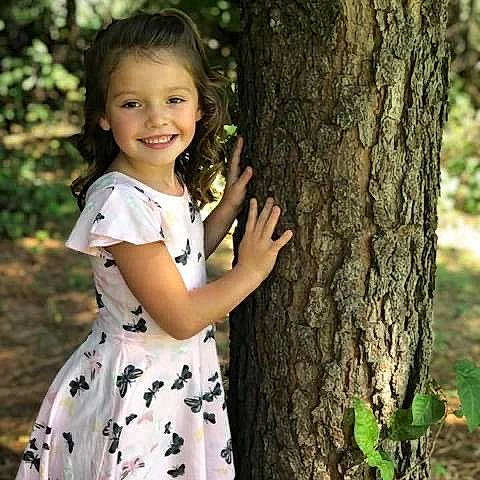 Miley is registered to the contest to win money with this photo: arm, botany, branch, eye, face, facial_expression, flash_photography, hair, hairstyle, hand, happy, head, human_body, joy, leaf, people_in_nature, person, plant, shoulder, sleeve