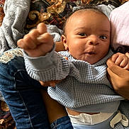 Ace joined the competition — help win amazing prizes! baby, infant, child, blue_clothing, denim, hand, fist, face, expression, curiosity, person, sitting, blanket, patterned, indoor, candid, portrait, cute, holding, cozy