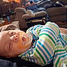 baby, sleeping, pacifier, striped_clothing, infant, closeup, indoor, cozy, sofa, person, relaxing, home, casual, furniture, blanket, child, comfort, peaceful, rest, nap