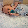 Noah is registered to the contest to win money with this photo: baby, infant, pacifier, blanket, blue_onesie, cartoon_print, lying_down, bed, cute, soft_texture, child, newborn, face, hand, sleepwear, head, comfort, indoors, pattern, resting