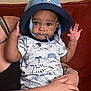 baby, baseballcap, bodypart, cap, clothing, couch, cushion, face, finger, furniture, hand, hat, head, homedecor, person, photography, portrait, skin, t_shirt, tattoo