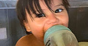 Davidson Flores is registered to the contest to win money with this photo: baby, bottle, casual, child, childhood, colorful_balls, cute, drinking, face, hair, hand, happy, indoor, orange_liquid, person, playpen, playtime, smiling, toddler, toy