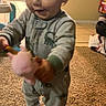 toddler, child, pajamas, toy, carpet, indoor, smiling, dinosaur, footwear, person, baby, crawling, cute, home, floor, playtime, furniture, soft_toy, warm_lighting, living_room