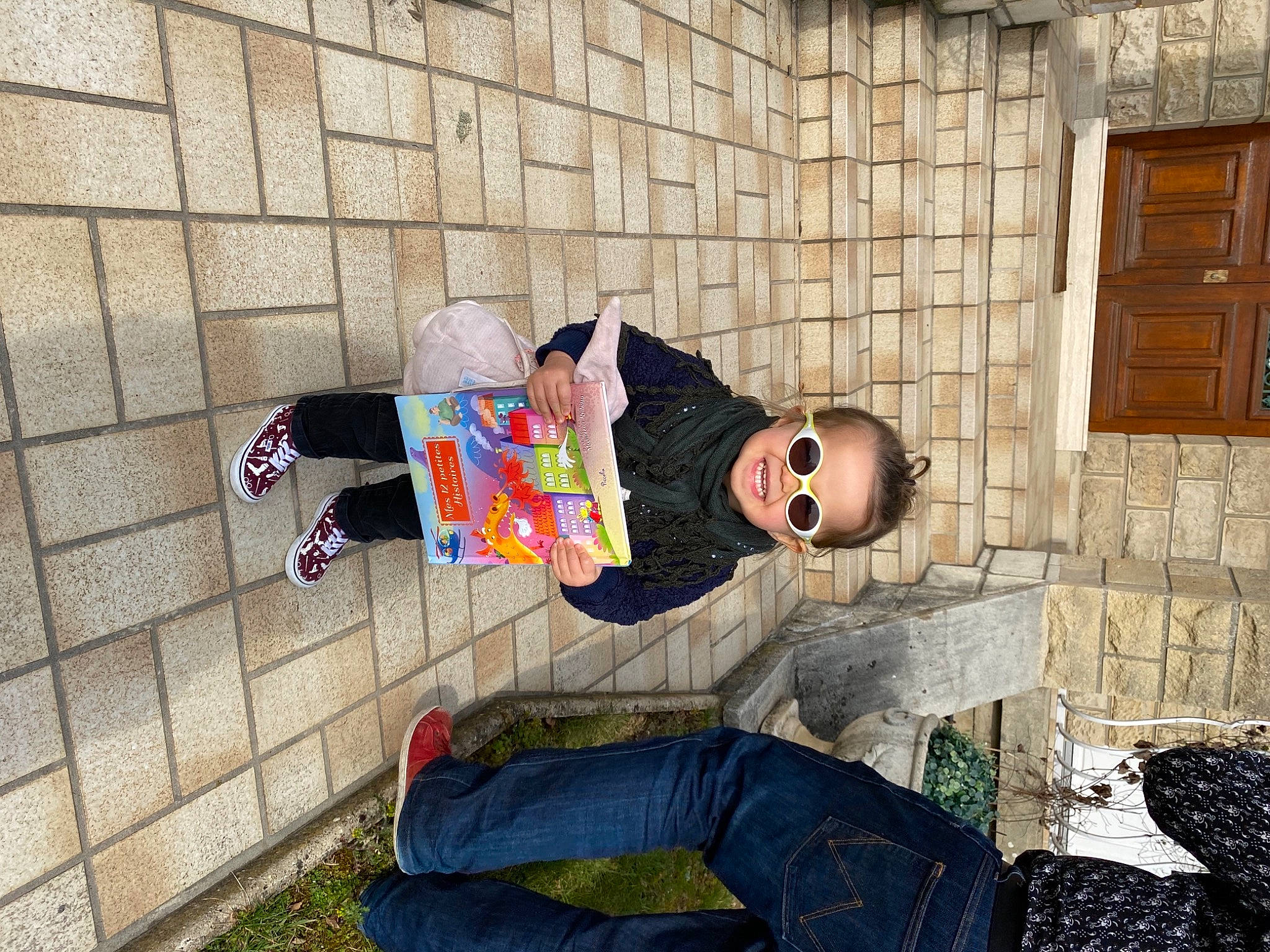 Marceline a rejoint le concours — aidez-le/la à gagner de superbes lots ! brick, brickwork, child, cobblestone, concrete, eyewear, flooring, fun, grass, hat, leisure, person, sitting, street, street_fashion, t_shirt, tree, vacation, visual_arts, window