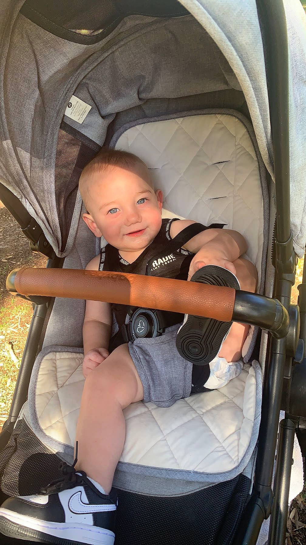 Arlo is registered to the contest to win money with this photo: auto_part, baby, baby_carriage, baby_products, car_seat, chair, child, comfort, flash_photography, fun, human_leg, joy, lap, leg, person, product, sitting, smile, thigh, tire