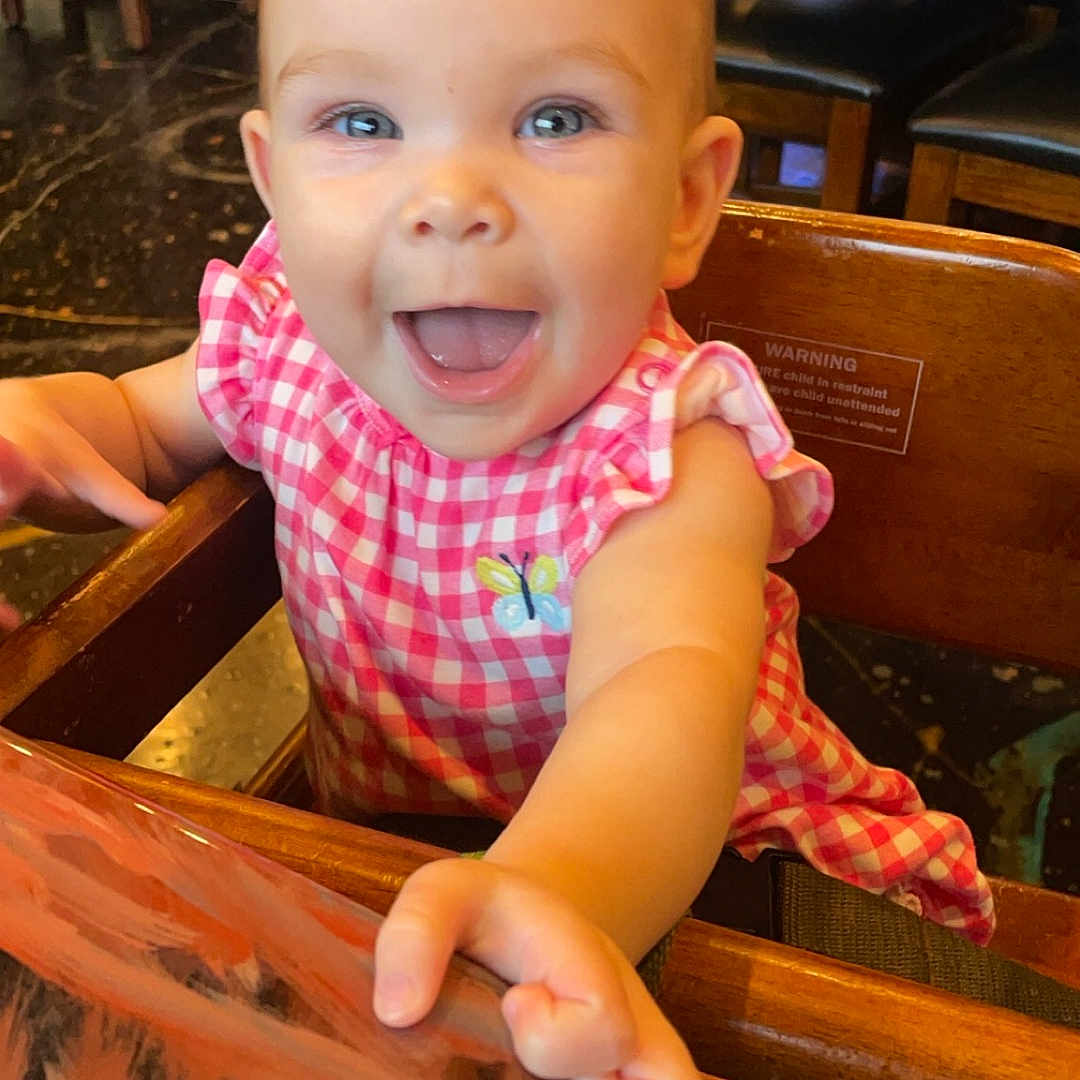 Shelly joined the competition — help win amazing prizes! architecture, baby, building, chair, cutlery, diningtable, face, furniture, happy, head, indoors, laughing, person, photography, portrait, restaurant, sitting, spoon, table, wood