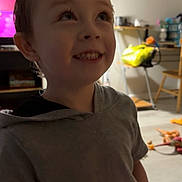 Treysen joined the competition — help win amazing prizes! background, boy, casual_clothing, chair, child, curious, floor, furniture, happy, home, hoodie, indoor, lamp, living_room, person, playtime, smile, table, television, toy