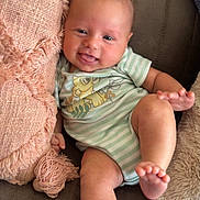 Jonah is registered to the contest to win money with this photo: baby, child, comfort, couch, cute, happy, indoor, infant, lion_print, onesie, pillow, playful, portrait, relaxed, seated, small_person, smiling, soft_fabric, striped_clothing, textured_pillow