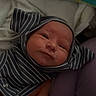 Jonah is registered to the contest to win money with this photo: baby, infant, smile, striped_clothing, hood, blanket, hand, person, newborn, soft, baby_wipes, purple_pants, cozy, cute, skin, face, expression, lying_down, child, comfort