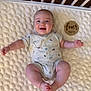 Emmett is registered to the contest to win money with this photo: baby, infant, crib, blanket, onesie, smiling, face, wooden_plaque, milestone, age_marker, cute, child, lying_down, happy, home, soft_texture, furniture, skin, person, newborn