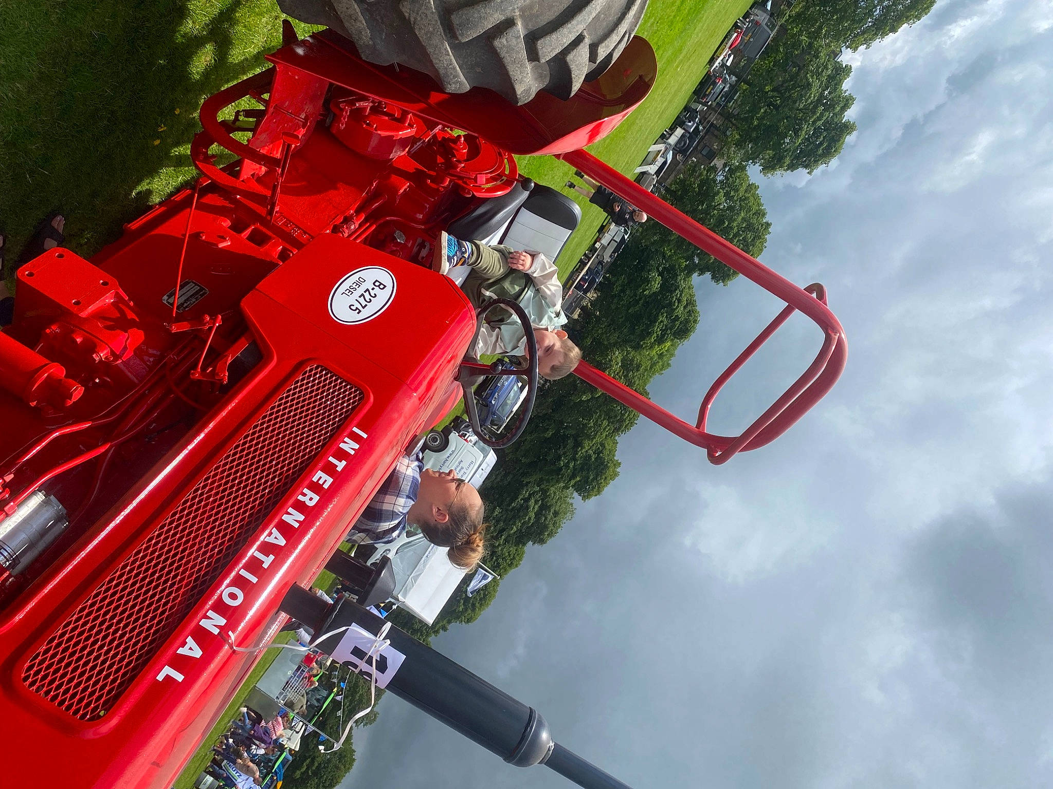 Eric is registered to the contest to win money with this photo: auto_part, automotive_design, automotive_exterior, automotive_lighting, automotive_tire, automotive_wheel_system, bumper, cloud, event, fun, hood, leisure, motor_vehicle, person, red, sky, tire, travel, tree, vehicle