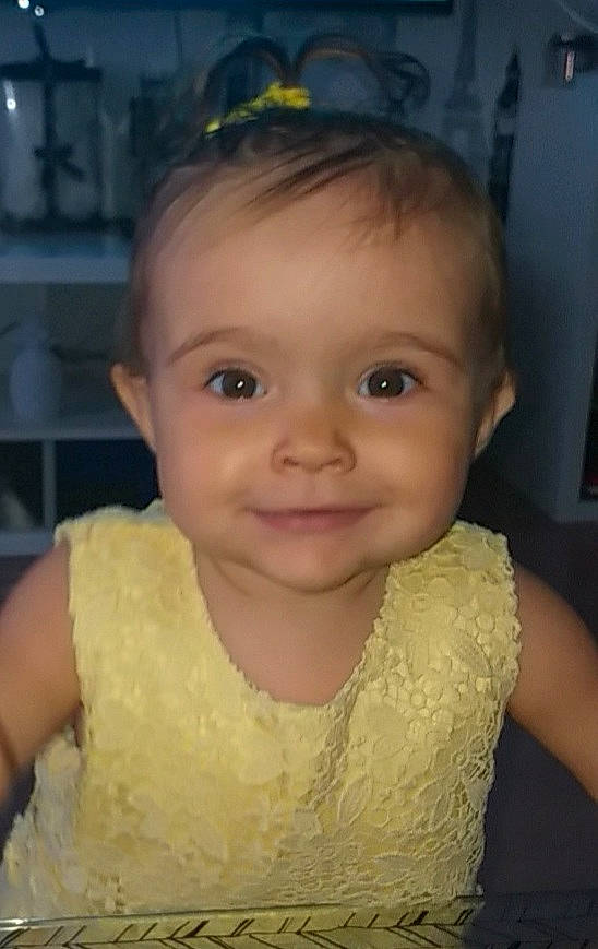 Luciana participe au concours pour gagner de l'argent avec cette photo : baby, baby_toddler_clothing, beauty, cheek, child, dress, eyebrow, eyelash, forehead, hair, hairstyle, happy, headgear, iris, joy, lip, nose, person, skin, sleeve