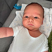 Filip is registered to the contest to win money with this photo: baby, blanket, child, chubby_cheeks, clothing, cozy, cute, expressionless, face, head, indoors, infant, lying_down, newborn, pacifier, portrait, resting, skin, soft_surface, white_clothing