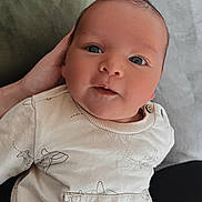 Filip joined the competition — help win amazing prizes! baby, infant, face, hand, clothing, airplane_pattern, eyes, portrait, cute, child, skin, sitting, support, expression, soft, comfort, person, indoors, young, newborn