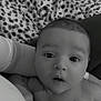 Filip is registered to the contest to win money with this photo: baby, infant, face, eyes, expression, blanket, pattern, soft, skin, person, newborn, curious, portrait, monochrome, black_and_white, clothing, hand, cuddle, comfort, closeup