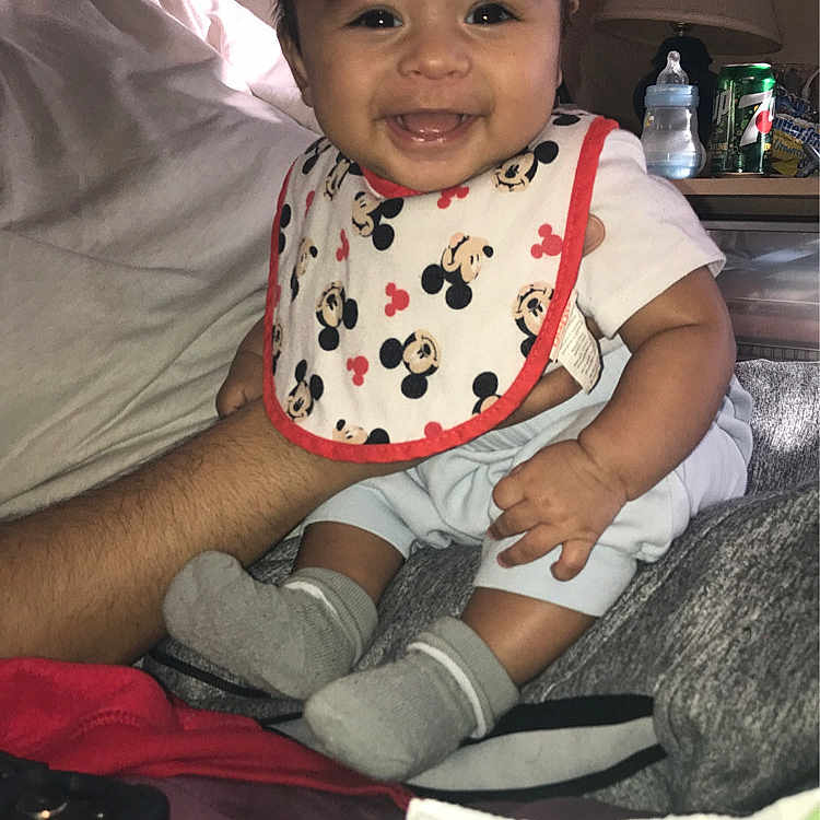 Santos is registered to the contest to win money with this photo: baby, bodypart, clothing, couch, cushion, face, finger, furniture, happy, head, homedecor, hosiery, indoors, lamp, person, photography, portrait, sitting, smile, sock