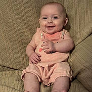Lillianna is registered to the contest to win money with this photo: baby, infant, smile, onesie, peach, blanket, texture, sitting, happy, cute, portrait, child, fingers, feet, skin, head, face, indoor, comfort, cozy