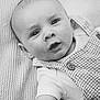 Waylon is registered to the contest to win money with this photo: baby, infant, black_and_white, close_up, texture, blanket, clothing, overall, face, eyes, arm, expression, portrait, cute, child, young, skin, baby_garment, monochrome, laying_down