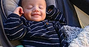 Josiah joined the competition — help win amazing prizes! baby, bed, blanket, child, comfort, cozy, cute, face, happy, indoors, infant, onesie, pacifier, portrait, resting, sleeping, smiling, soft_texture, striped_clothing, warm