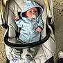 baby, pacifier, hoodie, stroller, cushion, pavement, footwear, socks, person, infant, clothing, outdoor, child, casual, transport, young_child, cute, comfort, seat, hood