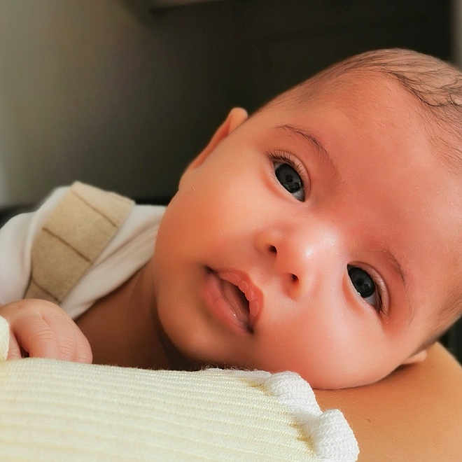 Numa participe au concours pour gagner de l'argent avec cette photo : baby, blanket, child, closeup, curious, cute, expression, eyes, face, hand, head, indoors, infant, newborn, person, portrait, resting, skin, soft, young